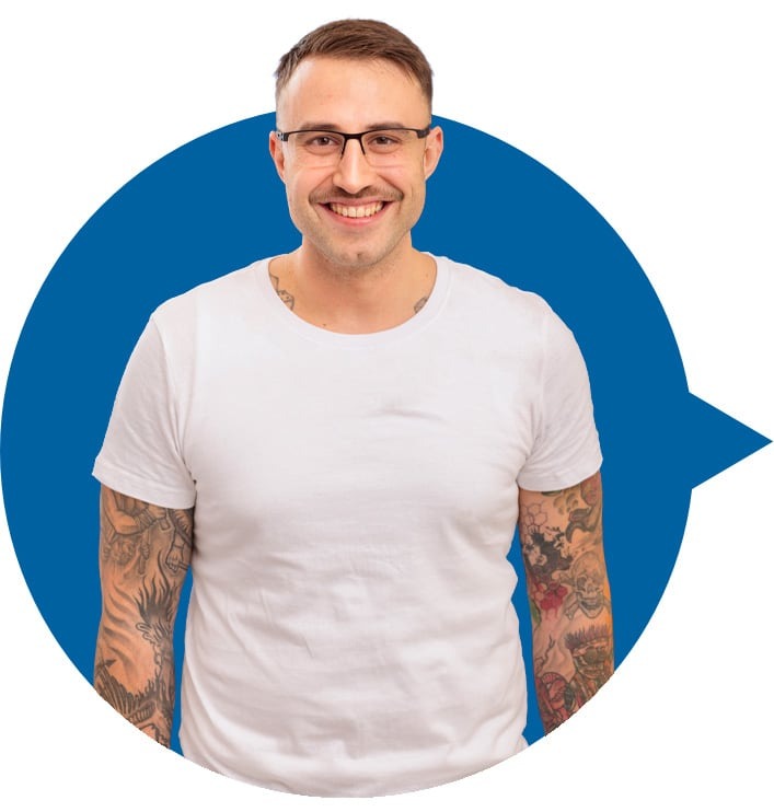 Mann mit kurz geschnittenem Haar, weißem T-Shirt und tätowierten Armen vor blauem Sprechblasensymbol